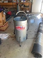 Front view of the metal BRUT sandblaster on wheels showing the logo and hose