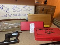 Overall view of all tools included in the lot showing Snap-On red case, Micinside and MacroTools boxes, and one clamp tool