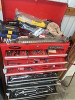 overview of red Craftsman tool chest top with various tools and accessories in top nine drawers