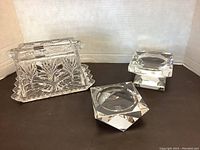 Front view of Rosenthal square candle holder and butter dish with lid on black surface.