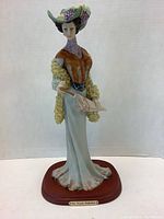 Front view of the Via Veneto lady figurine, showing details of the hat, gown, parasol, and base.