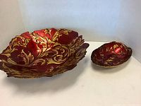 Both red and gold decorative bowls placed side by side on a white background showcasing their size difference and ornate gold pattern detailing.