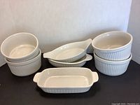 White ceramic Northland serveware including casserole dishes, oval baking dishes, and ribbed ramekins.