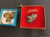 Three vintage jewelry pieces: gold filled ring, silver butterfly brooch in red Coro box, gold-colored dragonfly brooch in blue box.