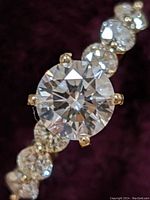 Close-up top view of the round brilliant center diamond and adjacent side stones