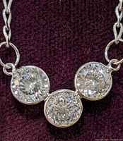 Close-up of three bezel-set round stones