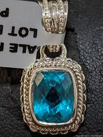 Close-up front view of sterling silver blue quartz pendant with rope border detailing.