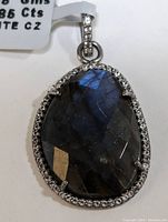 Front view of the sterling silver pendant showcasing the large faceted teardrop labradorite with surrounding cubic zirconia stones.
