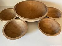 Overview of the full set with the large bowl at the center and four smaller bowls surrounding it, showing the wood grain and unfinished state.