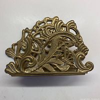 Top view showing intricate brass cut-out swirl and foliage design.