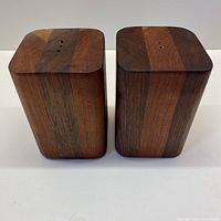 Front view showing the striped alternating teak wood panels on two square vintage salt and pepper shakers.