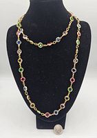 Full necklace displayed on black stand showing length and multi-colored crystals