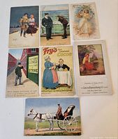 Seven antique postcards and advertising blotter laid out showing front artwork
