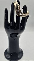 Sterling silver open cuff bangle bracelet displayed on black hand stand showing size and form.
