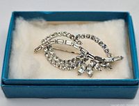 Brooch in blue box on white padding showing overall presentation and condition.