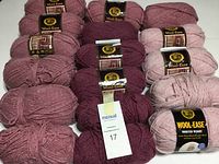 Photo showing skeins of Wool-Ease yarn in three different heather colors arranged on white surface.