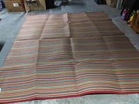 One Easy Sweep outdoor rug laid out flat showing multicolored horizontal stripes and full size coverage.