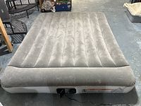 Full view of the queen size Bestway air mattress showing light gray velvet-like surface, vertical air chambers, and integrated pillow at one end.
