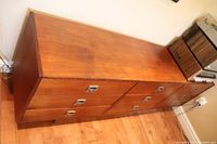 Full side-on view of long low dresser showing all nine drawers and top surface.