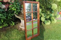 Front view of wooden framed mirror with 8 divided panes and natural outdoor background
