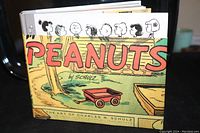 Front cover of the signed Peanuts book showing colorful cartoon art and title.
