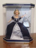 Front view of boxed Millennium Princess Barbie Doll showing doll in dark blue and silver gown with tiara and necklace, includes display accessory.