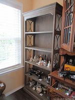Wooden bookcase shown in room corner with items on shelves for scale.