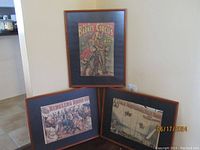 Three vintage circus posters framed and displayed together on a beige wall.