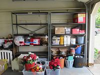 Photo showing two metal garage shelves with various items on and around them for scale and context.