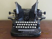 Front view of vintage Oliver Standard No. 5 typewriter showing dual curved typebars and round white keys.