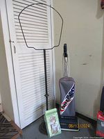 Photo showing the Oreck XL vacuum cleaner with a gray dust bag, metal stand, and several green sealed filter bags on the floor.