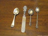 All 4 silver utensils displayed on wooden surface showing size and relative scale.