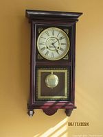 Front view of vintage Sunoco Oil Company pendulum wall clock hanging on wall, showing clock face, Sunoco logo, and decorative pendulum in a wood case.