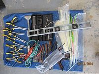 Overview photo showing assortment of tools: pliers, level, bolt remover set, bungie cords, cable ties.