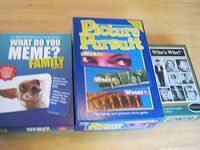Photo of the three game boxes: What Do You Meme? Family, Picture Pursuit, and Who's Who? showing their cover art and titles.