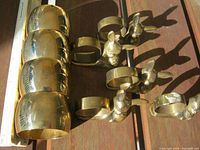 Four gold-tone wide cuff napkin holders and five silver-tone deer head napkin rings.