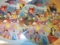 Close-up photo showing colorful artwork on two sides of the Disney Pinocchio picture disc LP featuring characters from the movie.