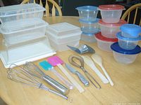 Overall view of kitchen utensils and plastic storage containers on table