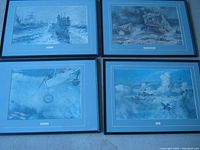 Four black framed WW1 prints with blue matting laid out on the floor, showing naval, battlefield, and aerial WW1 scenes.