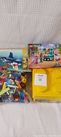 Photo showing Lego Creator Shark 31088 box, Lego Friends 41733 box and yellow Duplo container with mixed bricks and pieces.