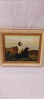Full view of the framed painting showing two Collie dogs outdoors with visible texture and colors on wood surface.
