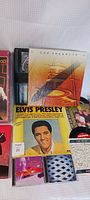 Photo showing Led Zeppelin 1-4 CD boxset, Elvis Presley record cover and sealed puzzle, partial view of other music items.