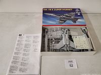 Open box view showing plastic model parts still on sprues, decal sheet, and instruction manual in good condition.