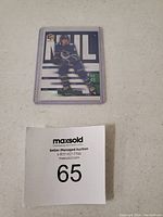 Front of Quinn Hughes hockey card in protective case showing player image and card design.