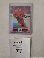 Front of the Tim Stutzle hockey card showing player in Ottawa Senators uniform with shiny holographic effect.