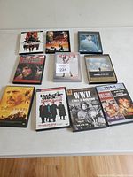 Top view of 10 wartime-themed DVD cases arranged on a white table, featuring titles related to World War II and other conflicts.