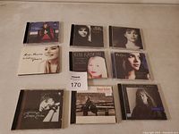 Photo showing 9 CDs by female artists arranged in a 3x3 grid on light surface.
