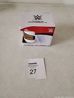 Photo of the ceramic coffee mug box showing WWE branding and product details alongside a lot number tag.