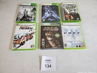 Photo showing six Xbox 360 game cases arranged in two rows of three, all in good condition with cover art visible.