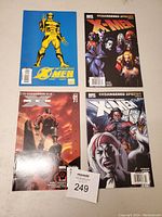 Four X-Men comic books laid out flat on a carpeted surface showing front covers.